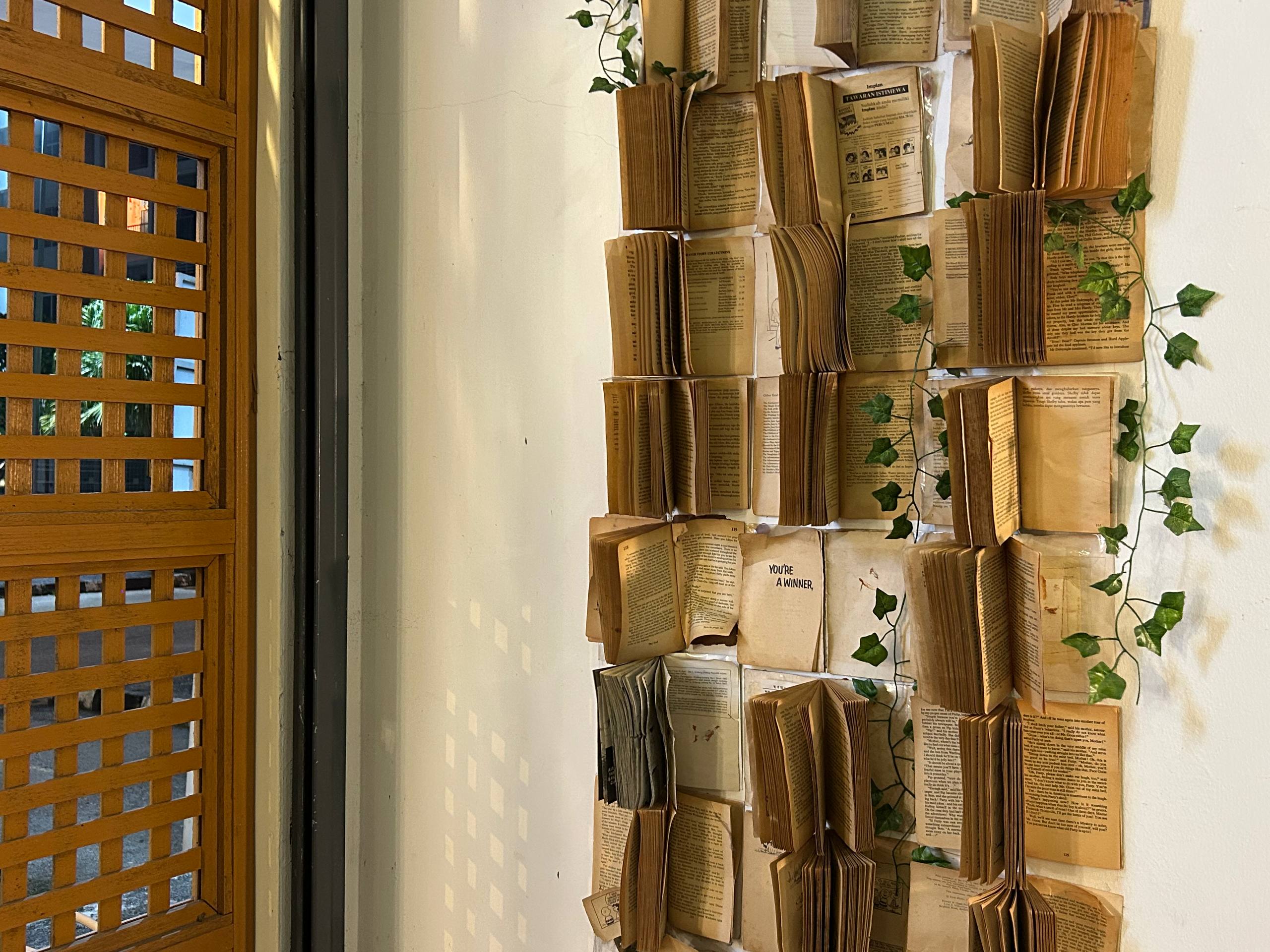 Vintage open books and trailing greenery arranged beside the cafe timber lattice.