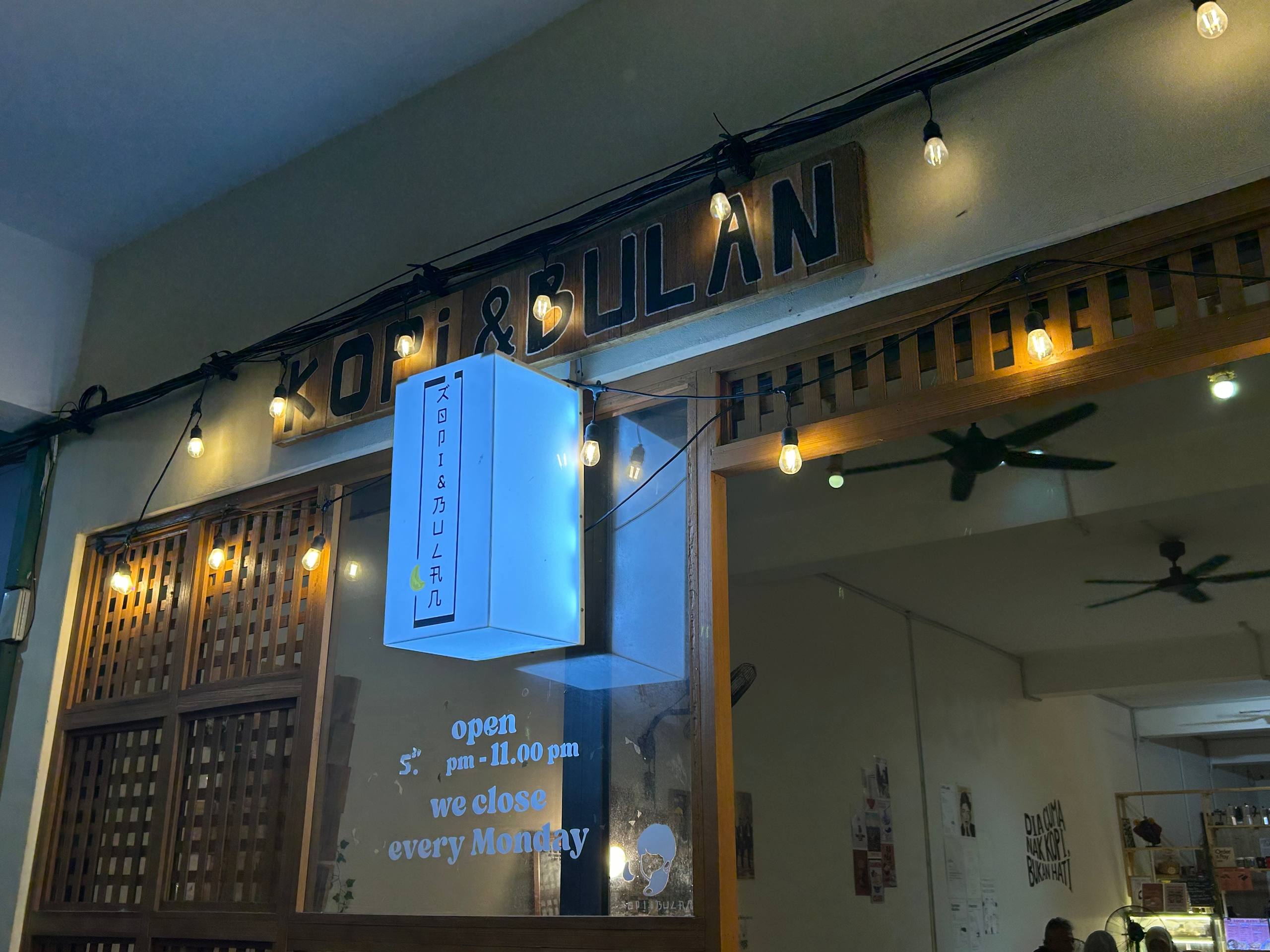 Close view of the Kopi & Bulan entrance and illuminated sign