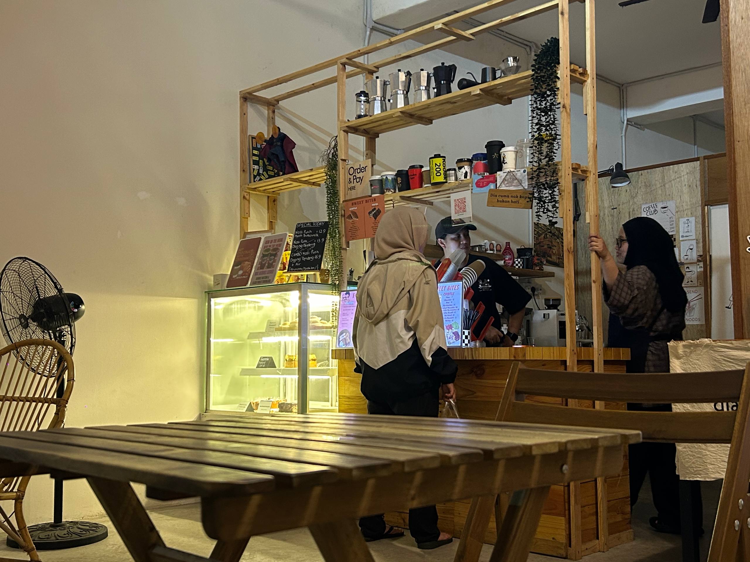 Customers ordering at the warm timber café counter